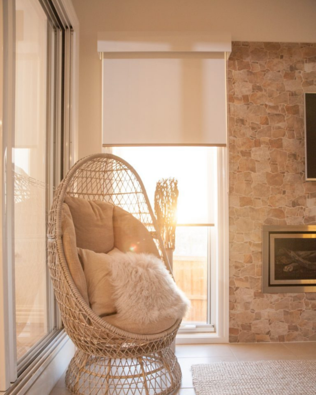 A picture of pelmets, with a egg chair and a fire place. 